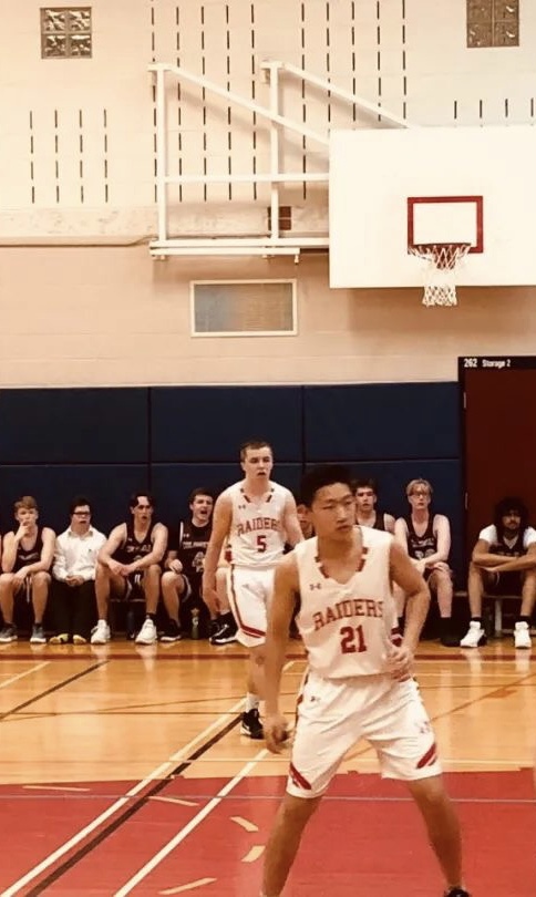 David playing basketball in a school gym